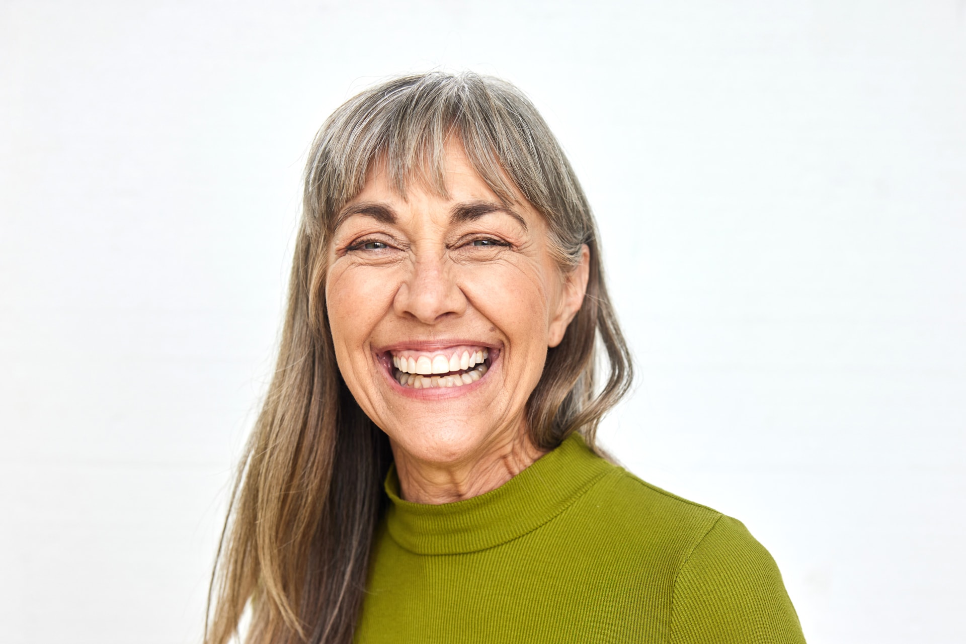 Erwachsene – lebensfrohe Frau in den mittleren Jahren Eine lebensfrohe Frau in den mittleren Jahren lächelt