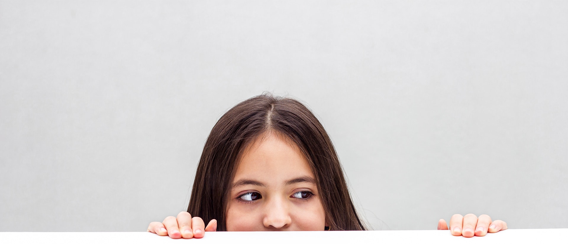 Mädchen schaut hinter dem Tisch hervor. Mädchen schaut hinter dem Tisch hervor.