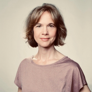 Frau schaut freundlich direkt in die Kamera