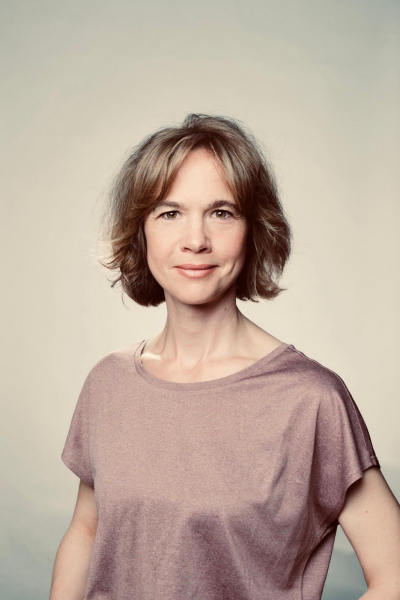 Hannah dram warm Frau schaut freundlich direkt in die Kamera